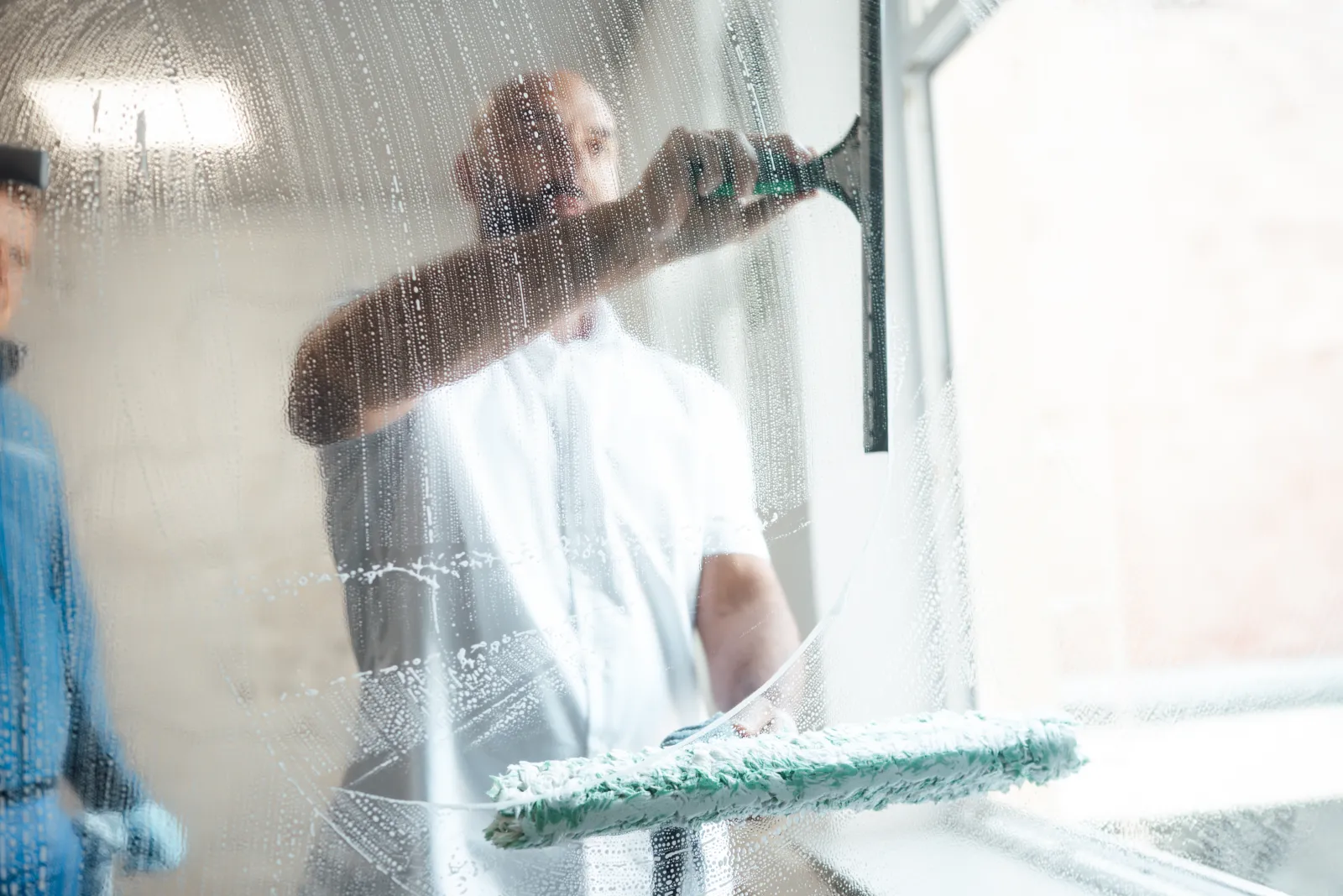 Fensterreinigung mit Einwascher und Abzieher an einer großen Glasfläche